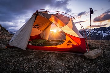 tent camping with mountain range and a sunstar
